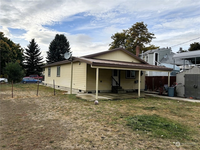 view of front of house with a storage unit and a front yard