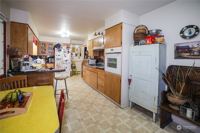 kitchen featuring a breakfast bar and white appliances