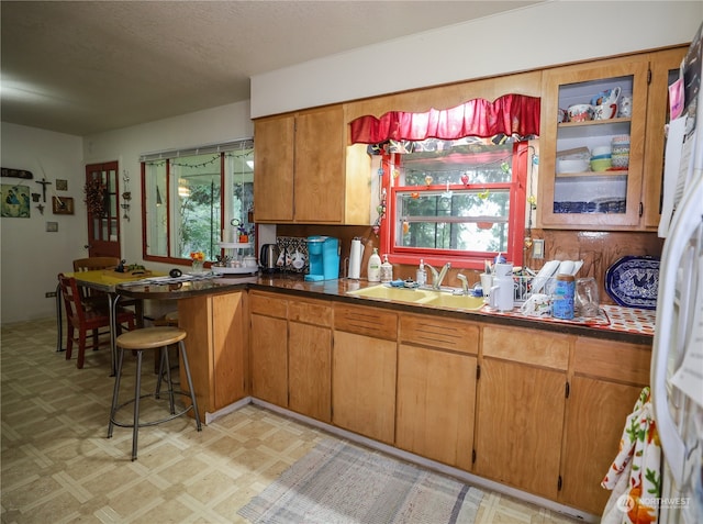 kitchen featuring a textured ceiling, white fridge, and sink