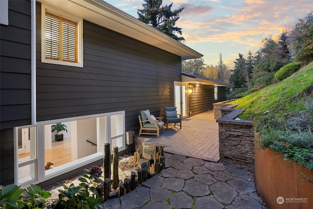 patio terrace at dusk featuring a wooden deck