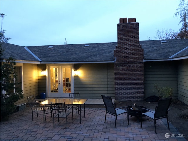 patio terrace at dusk featuring french doors and an outdoor fire pit