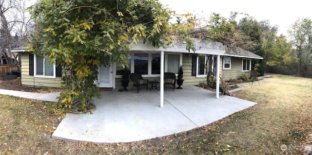 rear view of property with a yard and a patio area