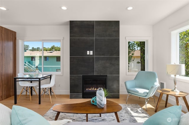 living room with light hardwood / wood-style flooring and a tile fireplace