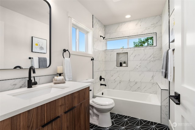 full bathroom featuring vanity, tiled shower / bath combo, toilet, and tile patterned floors