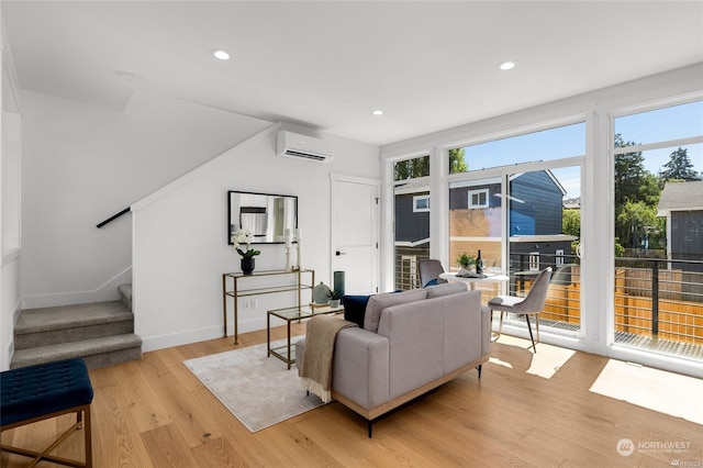 living room featuring a wall mounted AC and light hardwood / wood-style floors