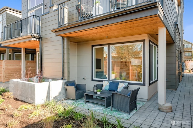 back of house with an outdoor living space, a patio, and a balcony