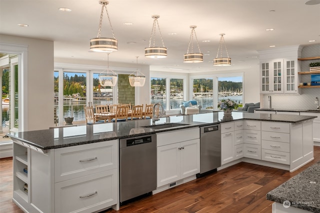 kitchen featuring stainless steel dishwasher, sink, white cabinetry, and a healthy amount of sunlight