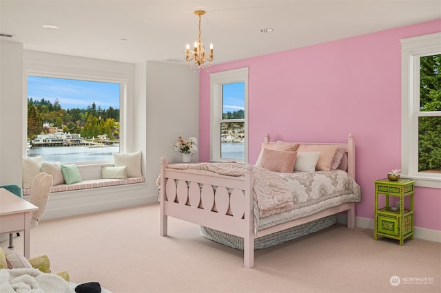 bedroom with multiple windows, carpet flooring, and a water view