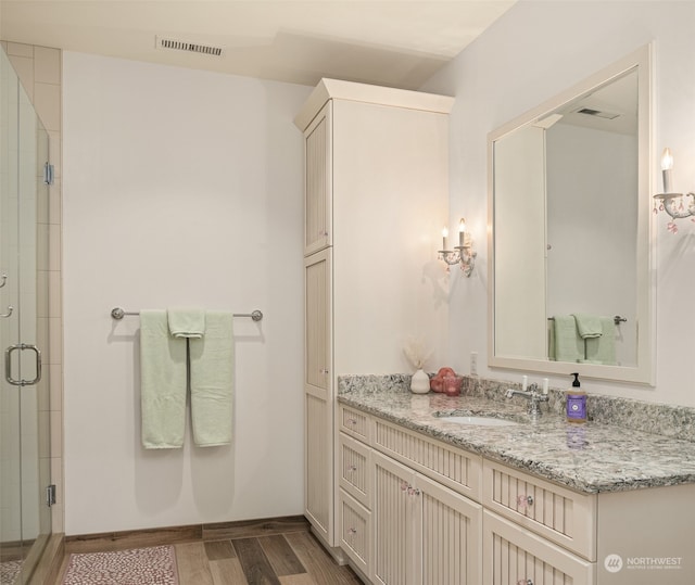 bathroom featuring vanity, hardwood / wood-style floors, and walk in shower