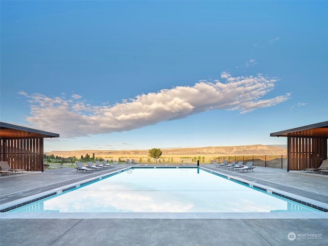 view of swimming pool featuring a mountain view and a patio area