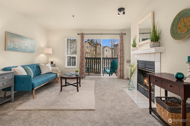 carpeted living room with a tile fireplace