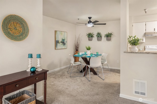 carpeted dining room featuring ceiling fan