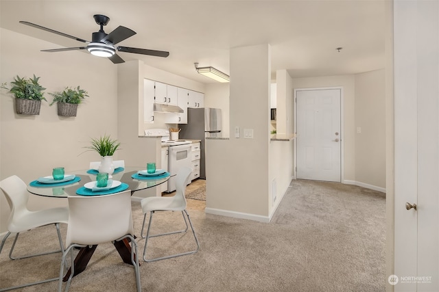 carpeted dining room featuring ceiling fan