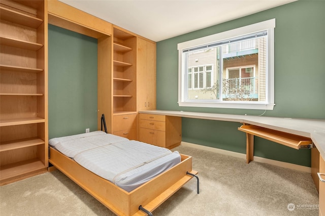 carpeted bedroom featuring built in desk