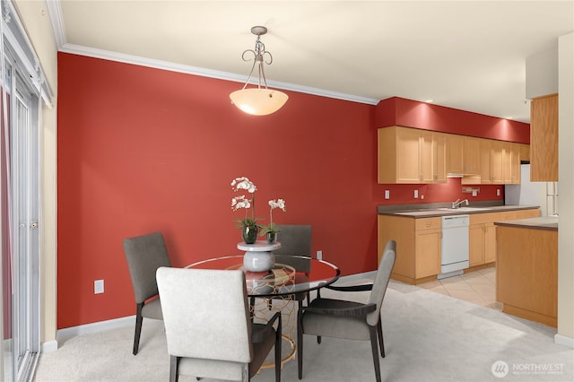 dining room with crown molding, sink, and light colored carpet