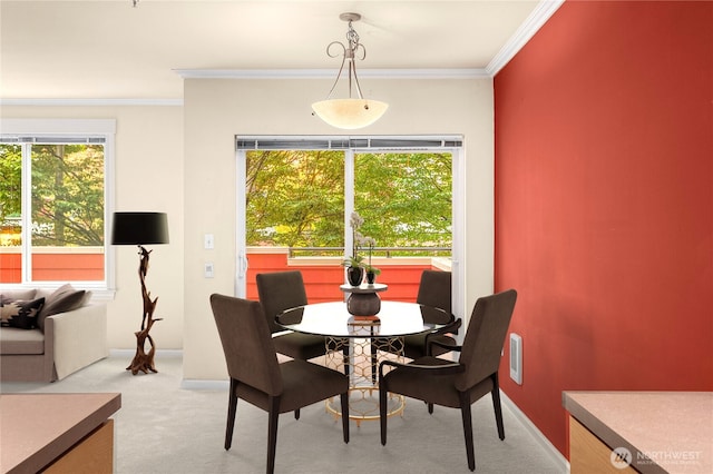 carpeted dining room featuring ornamental molding