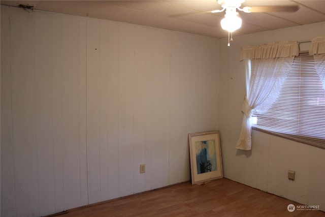 unfurnished room featuring wood walls and light hardwood / wood-style floors