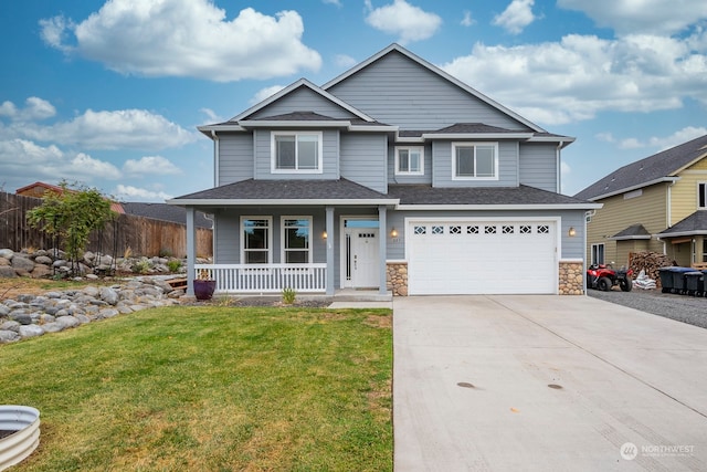 view of front of property featuring a front lawn, covered porch, and a garage