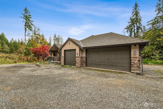 37122 237th Pl SE, Enumclaw, WA 98022 - view of front of home with a garage, stone siding, and gravel driveway