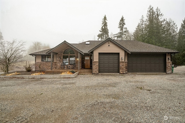 37122 237th Pl SE, Enumclaw, WA 98022 - ranch-style house with stone siding, a garage, gravel driveway, and roof with shingles