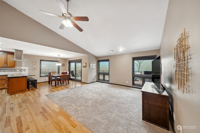 living room featuring ceiling fan, high vaulted ceiling, and light hardwood / wood-style floors