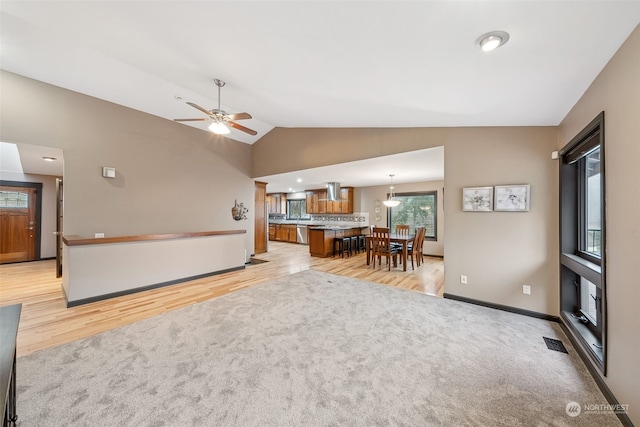 37122 237th Pl SE, Enumclaw, WA 98022 - living area featuring light wood-style floors, a ceiling fan, light colored carpet, and vaulted ceiling