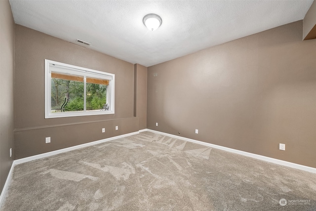 unfurnished room with a textured ceiling and carpet floors