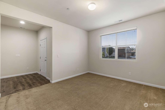 unfurnished room featuring dark carpet