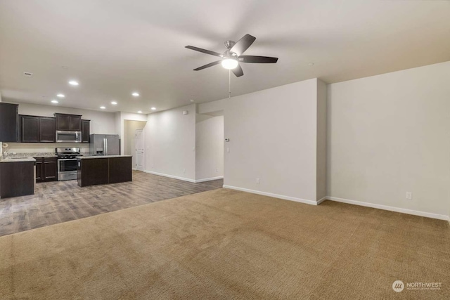 carpeted living room featuring sink and ceiling fan