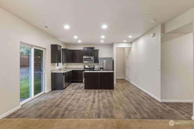 kitchen featuring stainless steel appliances, a kitchen island, hardwood / wood-style flooring, and sink