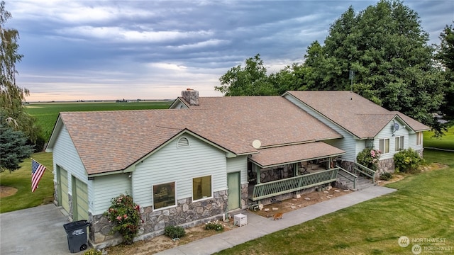 view of front of home featuring a garage, a lawn, and a porch