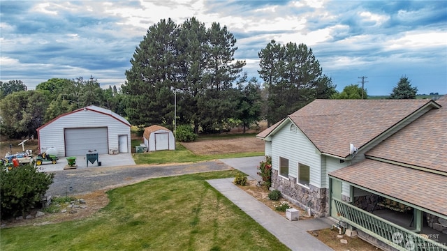 view of yard with a garage and an outbuilding