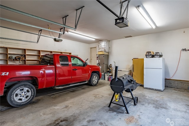 garage with a garage door opener and white fridge