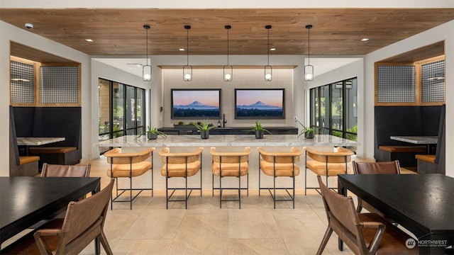 kitchen with a kitchen breakfast bar, wood ceiling, and decorative light fixtures