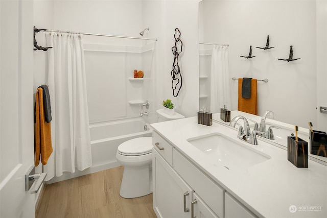 full bathroom featuring hardwood / wood-style floors, vanity, toilet, and shower / tub combo