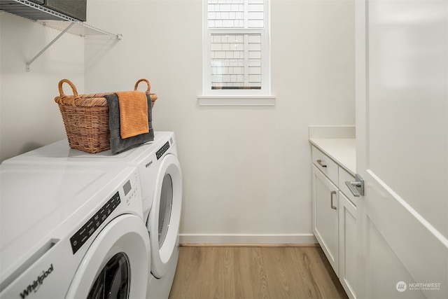 washroom with light hardwood / wood-style flooring, cabinets, and washer and dryer