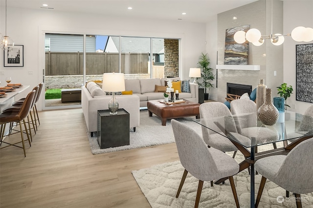 living room featuring light wood-type flooring and a fireplace