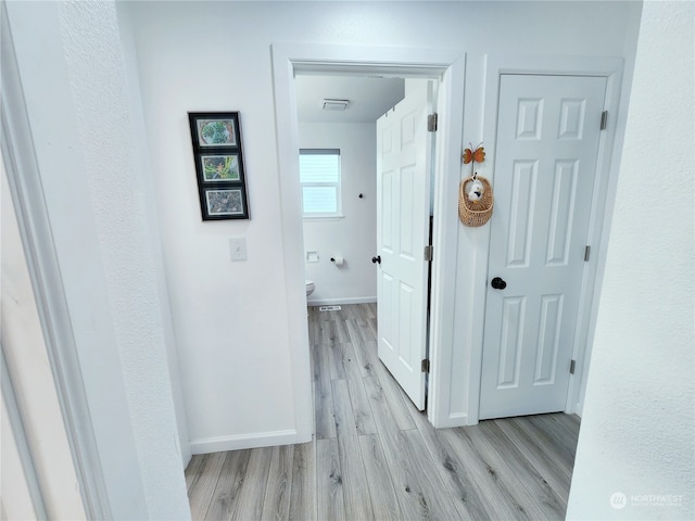 hallway with light hardwood / wood-style floors