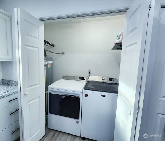 laundry area featuring washing machine and clothes dryer and light wood-type flooring