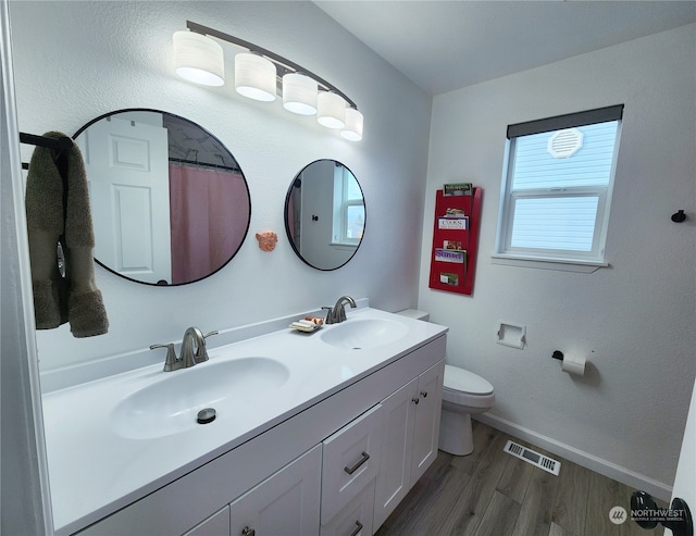 bathroom with hardwood / wood-style floors, curtained shower, vanity, and toilet