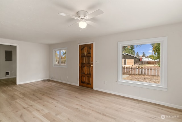 unfurnished room with a wealth of natural light, light hardwood / wood-style flooring, and ceiling fan