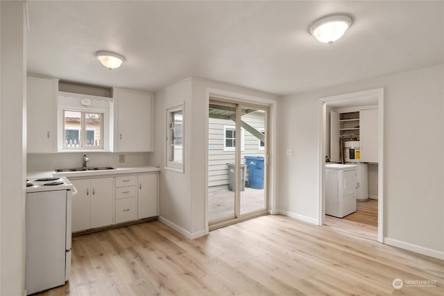 kitchen featuring white cabinetry, a healthy amount of sunlight, sink, and white stove