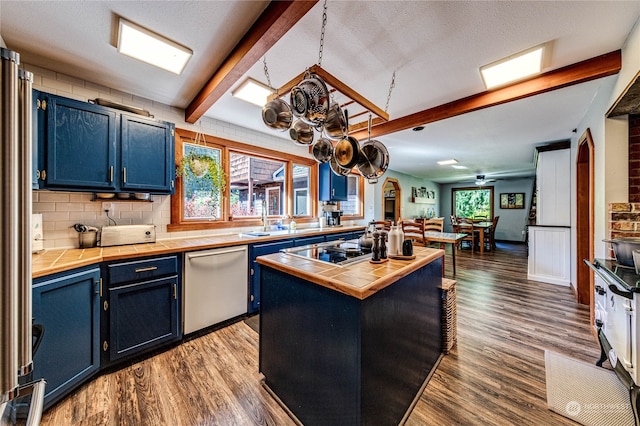 kitchen with dark hardwood / wood-style floors, a center island, stainless steel appliances, and a healthy amount of sunlight