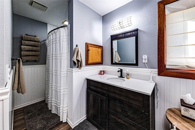 107 Dowans Creek Rd, Forks, WA 98331 - full bath featuring a wainscoted wall, vanity, wood finished floors, and curtained shower