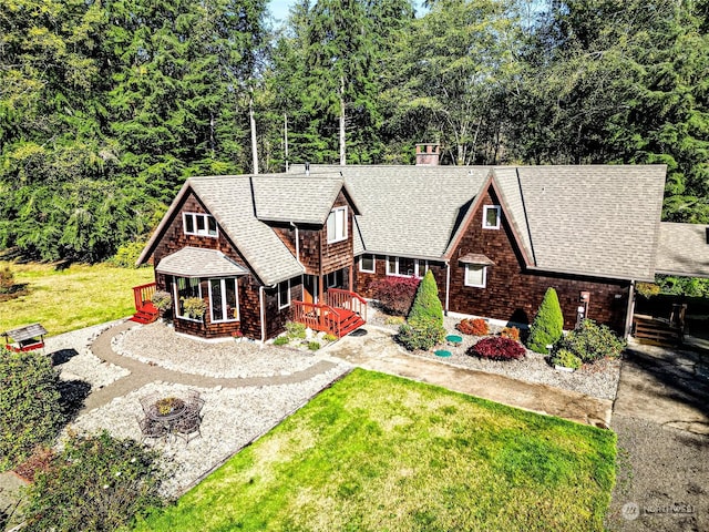 107 Dowans Creek Rd, Forks, WA 98331 - view of front of property with an outdoor fire pit, a shingled roof, a front yard, and a chimney