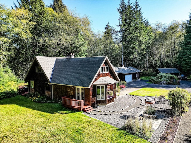 107 Dowans Creek Rd, Forks, WA 98331 - view of front of home featuring a detached garage, a shingled roof, an outdoor structure, a front lawn, and french doors