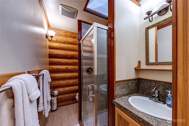 107 Dowans Creek Rd, Forks, WA 98331 - full bathroom featuring log walls, a stall shower, toilet, vanity, and tile patterned floors