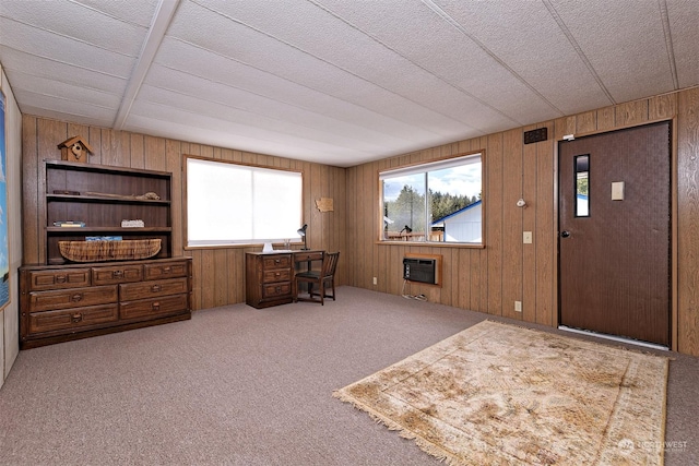 home office featuring wooden walls, a wall mounted AC, and carpet