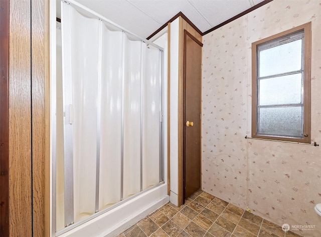 bathroom with crown molding and a shower stall