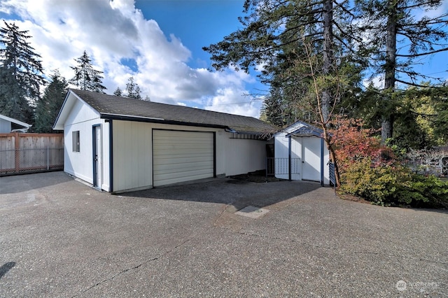 garage with fence and driveway